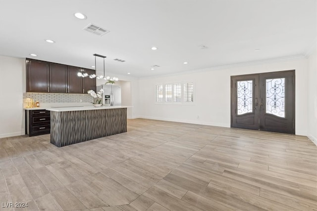 kitchen featuring a kitchen island, decorative light fixtures, and light wood-type flooring