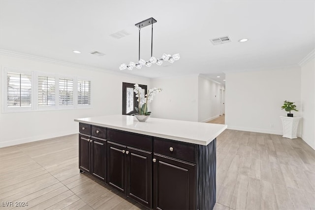 kitchen with hanging light fixtures, a chandelier, light wood-type flooring, a kitchen island, and ornamental molding