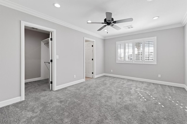 unfurnished bedroom featuring ceiling fan, a walk in closet, ornamental molding, and a closet