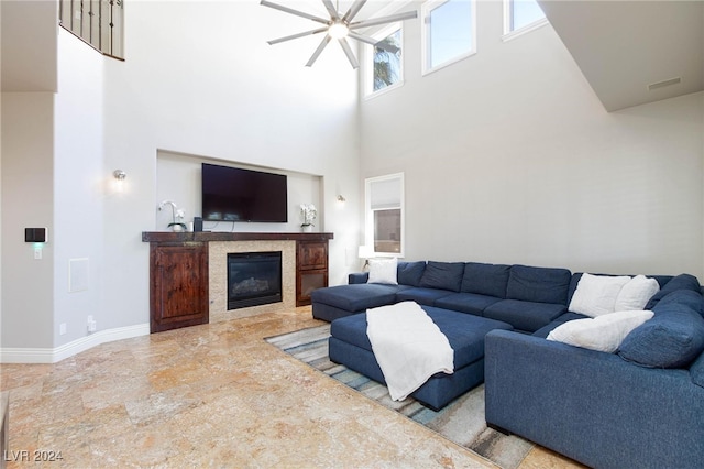 living room featuring ceiling fan and a high ceiling