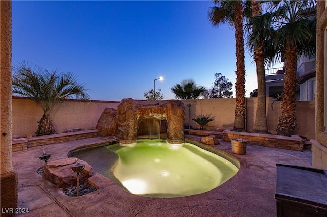 pool at dusk featuring a patio