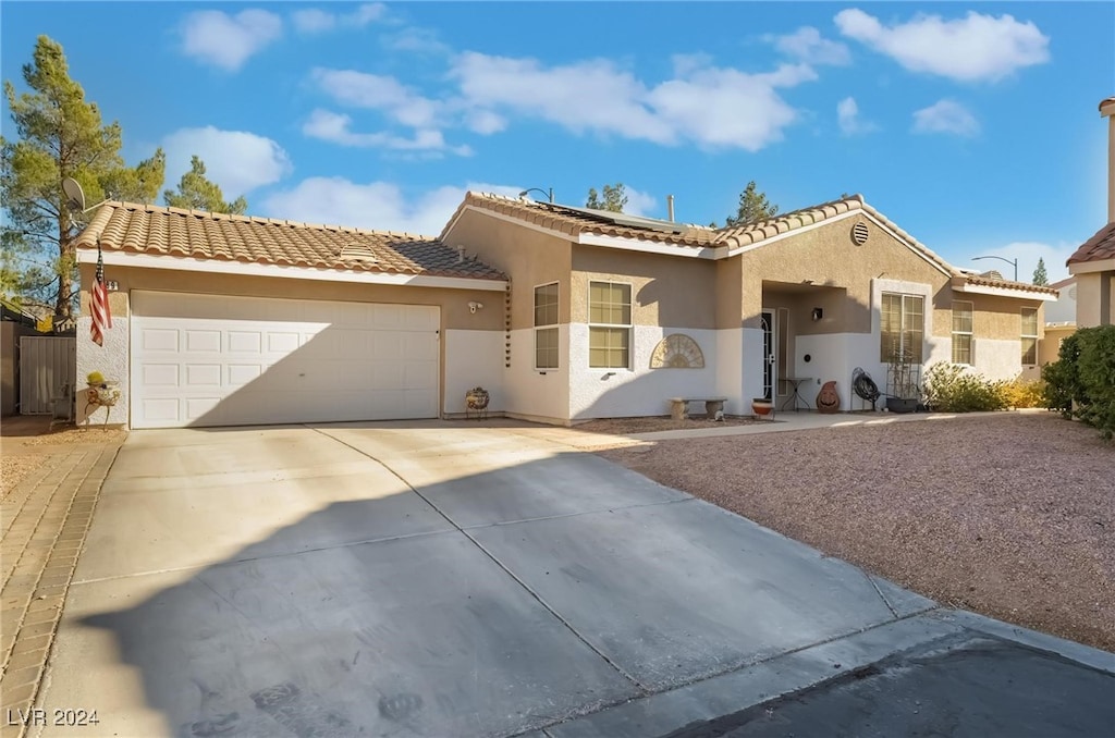 mediterranean / spanish-style home with a garage