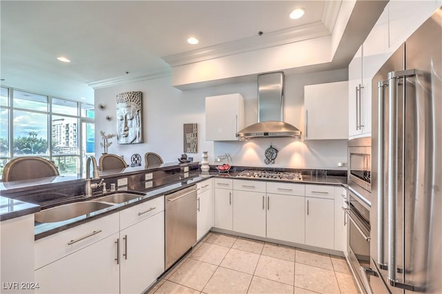 4525 Dean Martin Dr Unit 302, Las Vegas, NV 89103 - kitchen featuring wall chimney exhaust hood, appliances with stainless steel finishes, ornamental molding, white cabinetry, and light tile patterned floors
