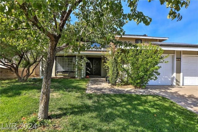 view of front of home featuring a front yard and a garage