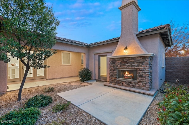 exterior space with a patio and an outdoor stone fireplace