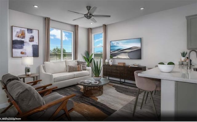 living room with ceiling fan, sink, and light wood-type flooring