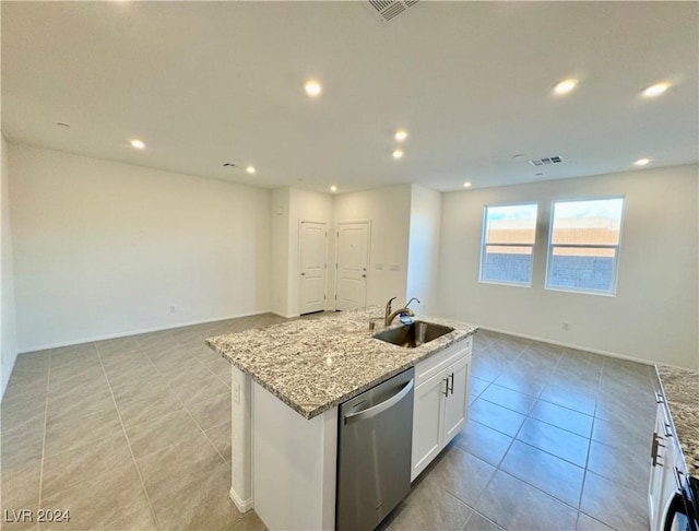 kitchen with sink, dishwasher, white cabinetry, light stone counters, and a center island with sink