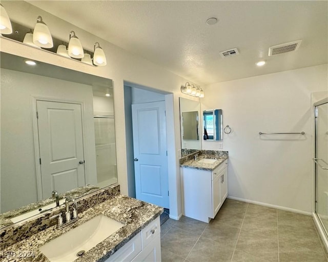 bathroom with vanity, tile patterned floors, and a shower with door