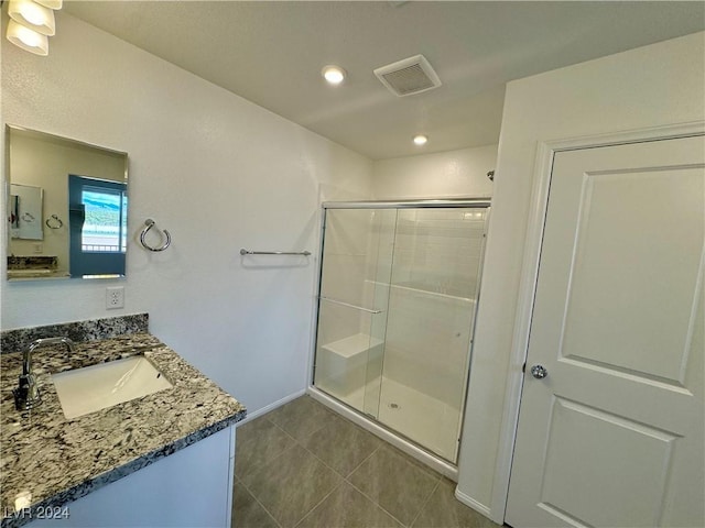 bathroom with tile patterned flooring, vanity, and a shower with shower door