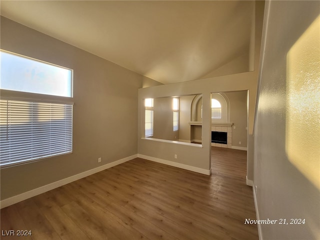 unfurnished living room featuring a fireplace, wood-type flooring, and lofted ceiling