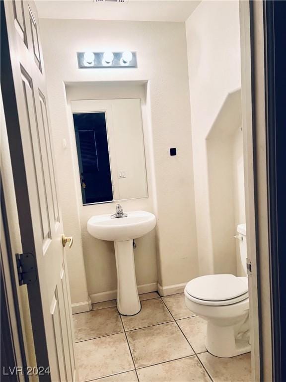 bathroom with toilet and tile patterned floors