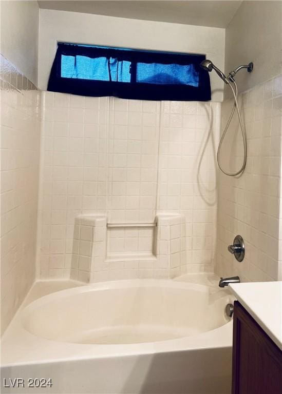 bathroom with vanity and tiled shower / bath