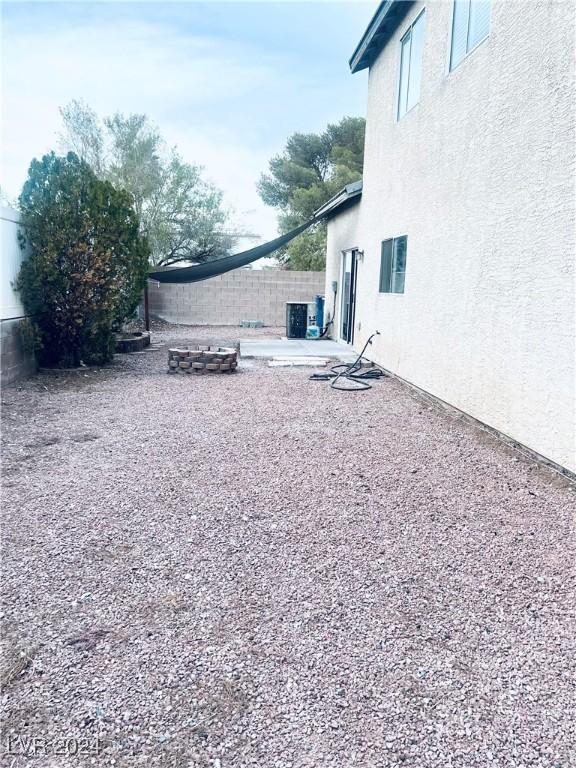 view of yard with a patio area, cooling unit, and an outdoor fire pit