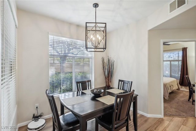 dining space featuring a healthy amount of sunlight, light hardwood / wood-style floors, and an inviting chandelier