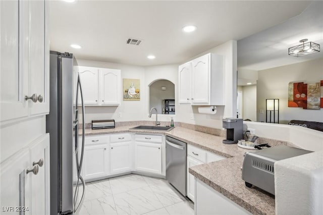 kitchen with sink, white cabinetry, kitchen peninsula, and appliances with stainless steel finishes