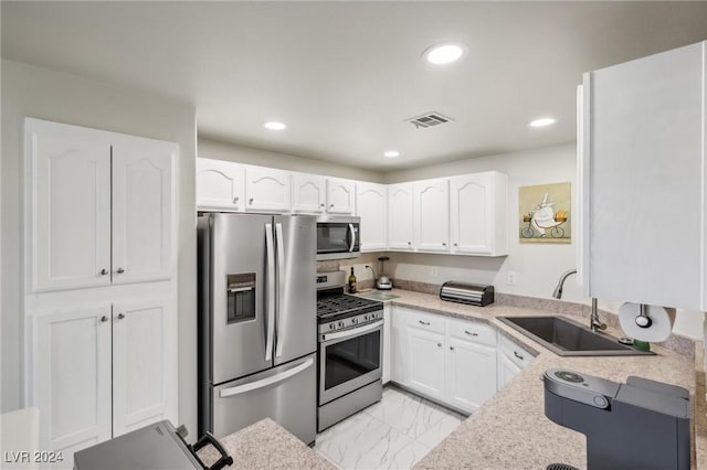 kitchen featuring appliances with stainless steel finishes, white cabinetry, and sink