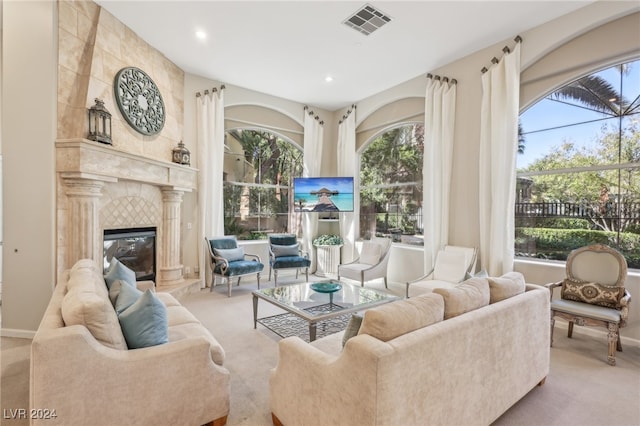 living room with a tile fireplace and light colored carpet