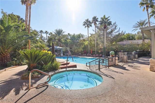 view of pool with a community hot tub and a patio area