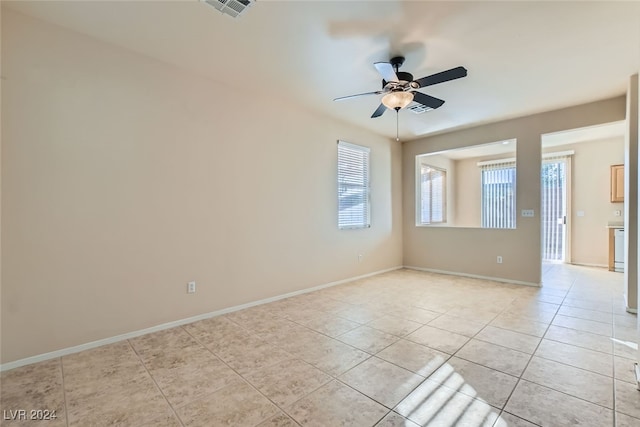 spare room with ceiling fan and light tile patterned flooring