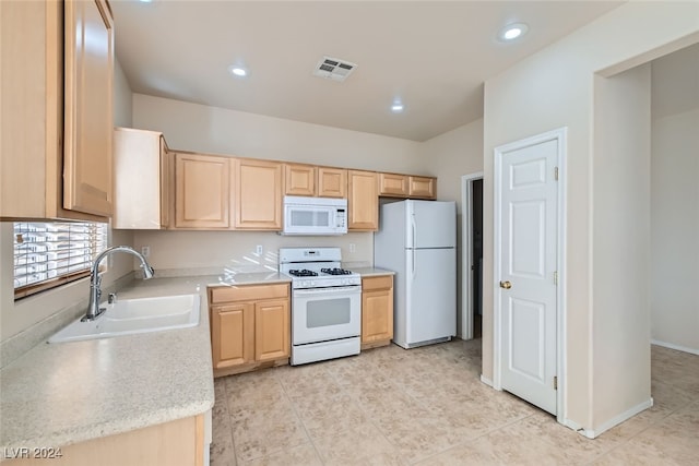 kitchen with light brown cabinetry, white appliances, light tile patterned floors, and sink