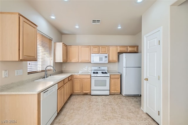 kitchen with light brown cabinetry, white appliances, and sink