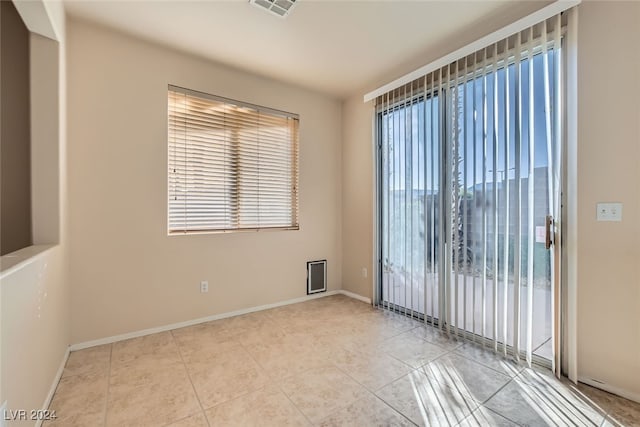 empty room featuring light tile patterned floors and plenty of natural light