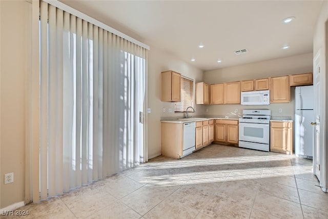 kitchen featuring sink, light tile patterned flooring, white appliances, and light brown cabinets