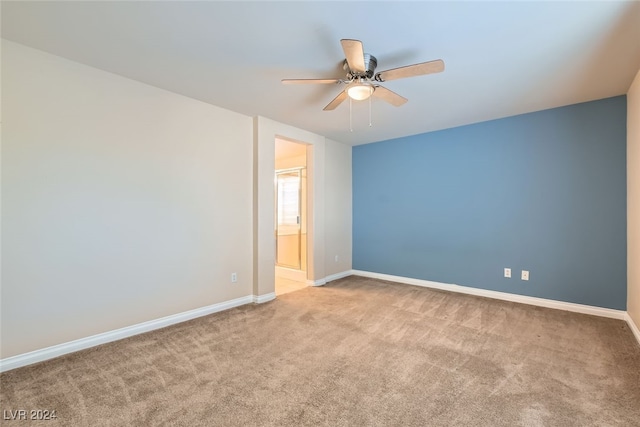 spare room with ceiling fan and light colored carpet