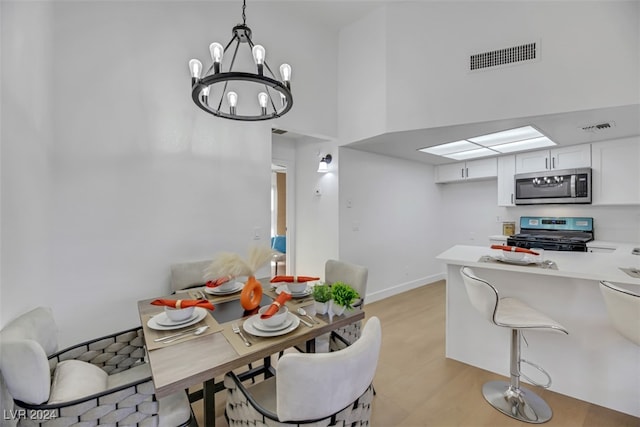 dining area featuring light hardwood / wood-style floors and a notable chandelier