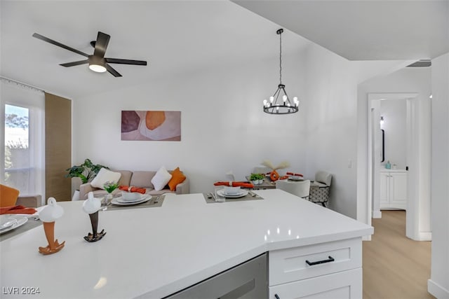 kitchen with ceiling fan with notable chandelier, decorative light fixtures, light hardwood / wood-style floors, white cabinetry, and lofted ceiling