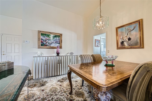 dining area with high vaulted ceiling and a chandelier