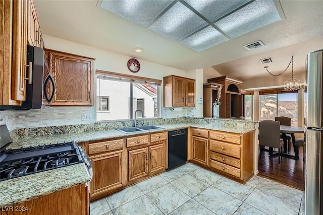 kitchen featuring black appliances, plenty of natural light, kitchen peninsula, and sink