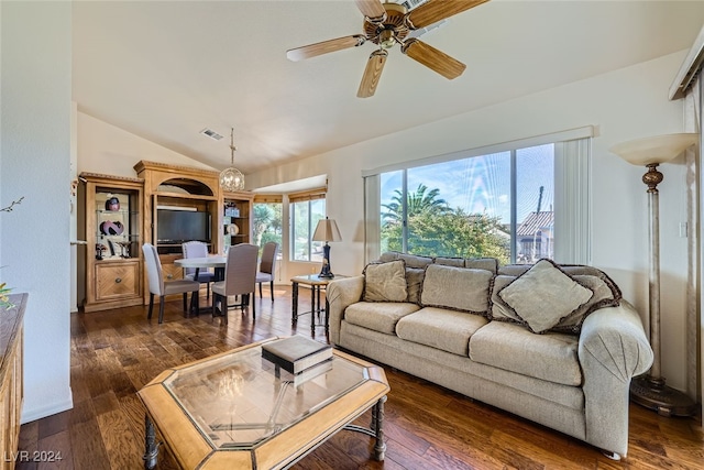 living room with ceiling fan with notable chandelier, dark hardwood / wood-style flooring, and lofted ceiling