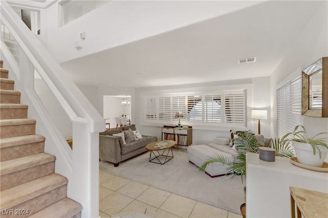 tiled living room featuring plenty of natural light and an inviting chandelier