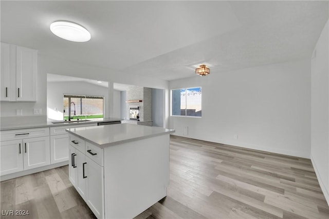 kitchen featuring sink, a kitchen island, white cabinets, and plenty of natural light