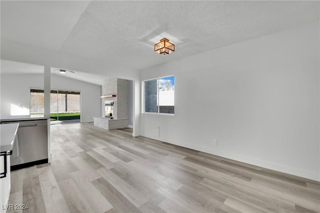 unfurnished living room featuring a fireplace, light hardwood / wood-style floors, and a healthy amount of sunlight