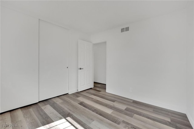 unfurnished bedroom featuring a closet and light wood-type flooring