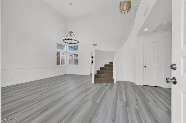 entrance foyer featuring a notable chandelier, a high ceiling, and light wood-type flooring