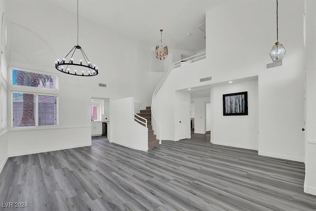 unfurnished living room with a towering ceiling and wood-type flooring