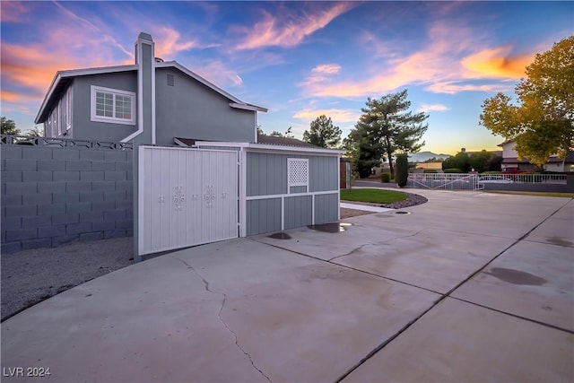 outdoor structure at dusk with a gate and fence