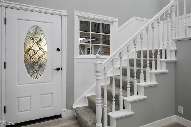 entryway with baseboards, stairs, and wood finished floors