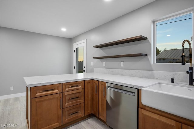 kitchen with a peninsula, light wood-style floors, open shelves, and stainless steel dishwasher