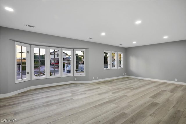 unfurnished room featuring baseboards, light wood finished floors, recessed lighting, and visible vents