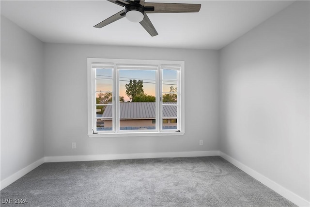 unfurnished room with carpet floors, a ceiling fan, and baseboards