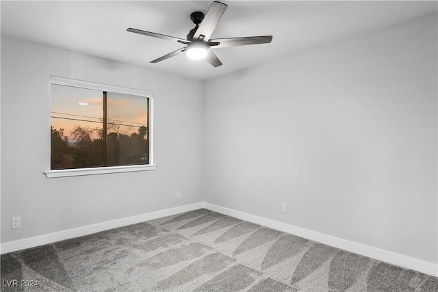 spare room featuring carpet flooring, baseboards, and a ceiling fan