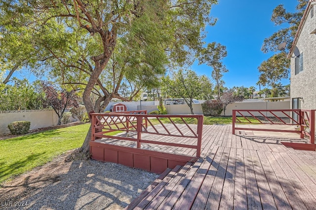 wooden terrace with a lawn and a storage unit