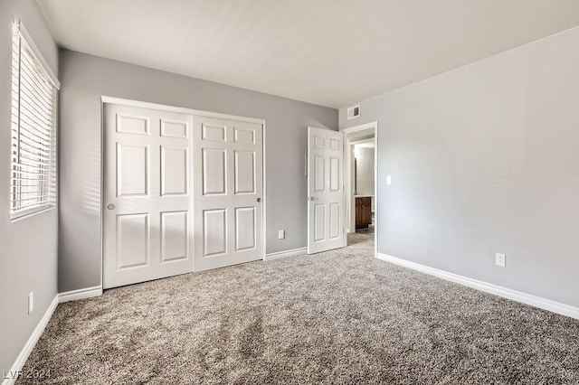 unfurnished bedroom with carpet and a closet