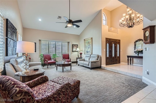 tiled living room featuring ceiling fan with notable chandelier and a high ceiling