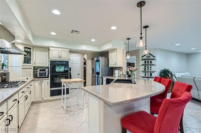 kitchen featuring sink, backsplash, decorative light fixtures, a breakfast bar, and appliances with stainless steel finishes