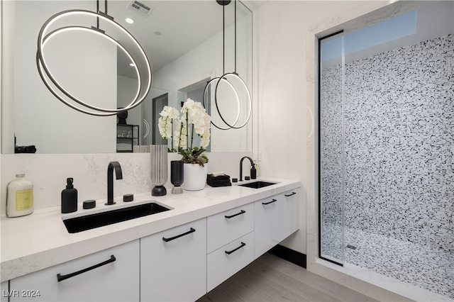 bathroom featuring vanity, a shower, wood-type flooring, and backsplash